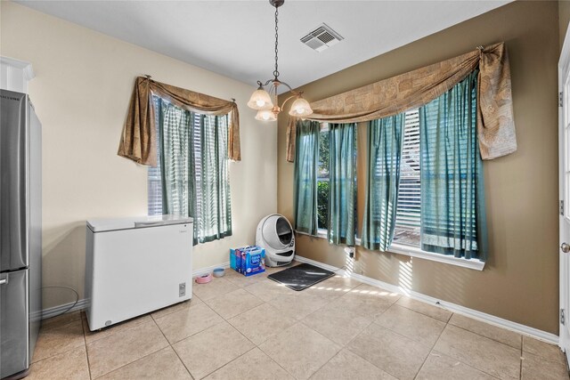 interior space with an inviting chandelier and a healthy amount of sunlight