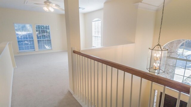 hall with carpet floors and an inviting chandelier