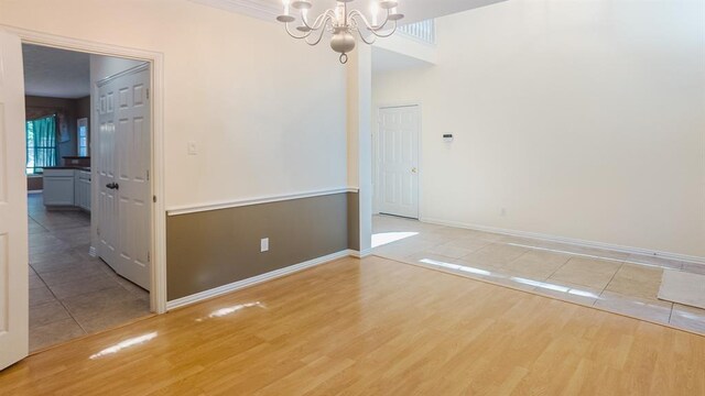 spare room featuring hardwood / wood-style floors and a notable chandelier