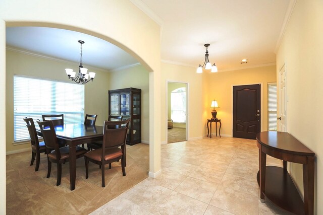 dining room with a notable chandelier, ornamental molding, and light tile patterned floors