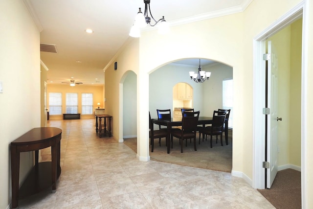 dining room featuring crown molding, light colored carpet, and ceiling fan with notable chandelier