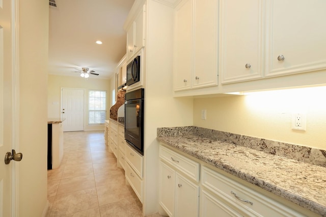 kitchen featuring light stone counters, ceiling fan, black appliances, white cabinets, and light tile patterned flooring