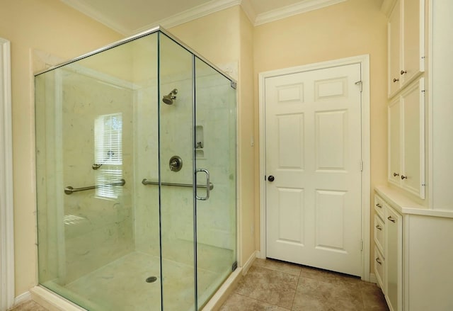 bathroom featuring tile patterned flooring, ornamental molding, and a shower with shower door