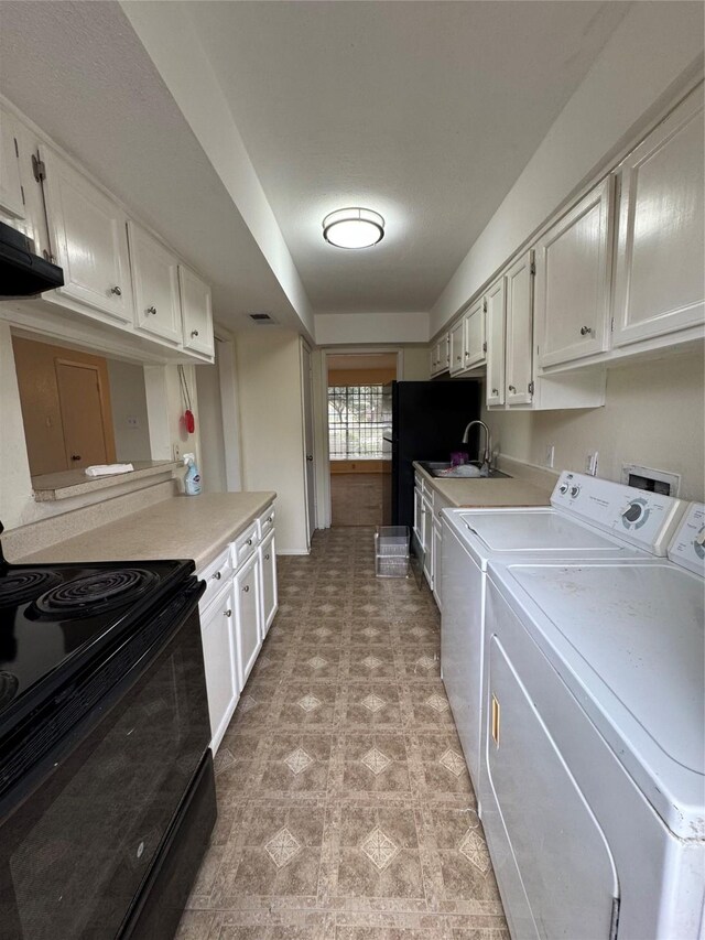 kitchen with washer and clothes dryer, ventilation hood, sink, black range with electric cooktop, and white cabinetry