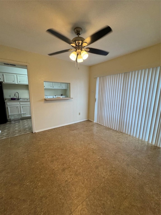 unfurnished living room with ceiling fan and sink