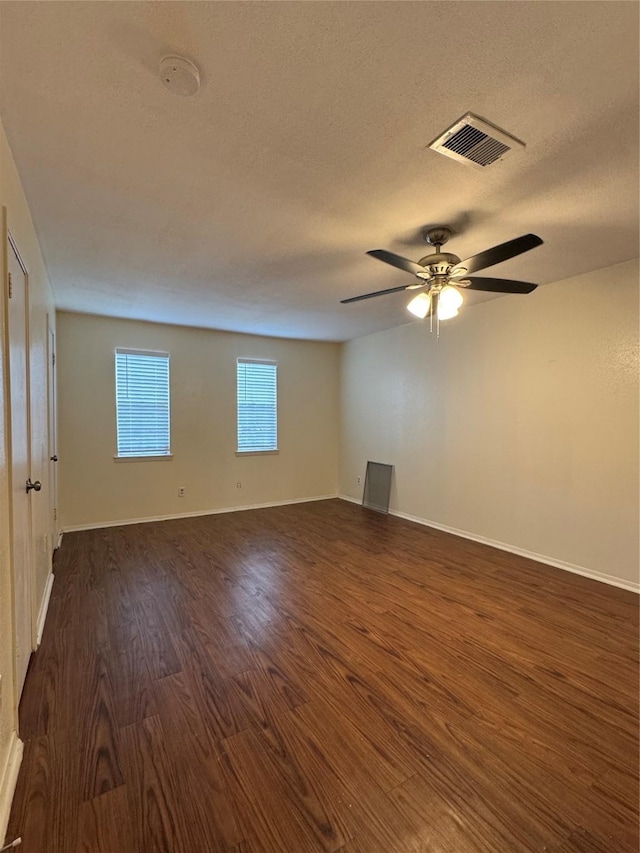 unfurnished room featuring a textured ceiling, ceiling fan, and dark wood-type flooring