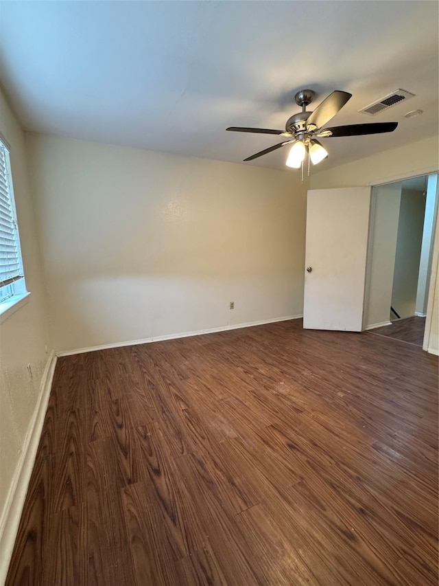 empty room with ceiling fan and dark hardwood / wood-style floors