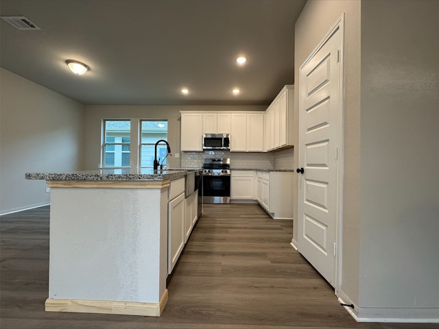 kitchen with recessed lighting, dark wood-style flooring, stainless steel appliances, tasteful backsplash, and visible vents