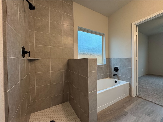 full bathroom featuring a garden tub, tiled shower, and wood finished floors