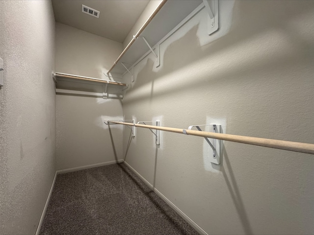 walk in closet featuring visible vents and dark colored carpet