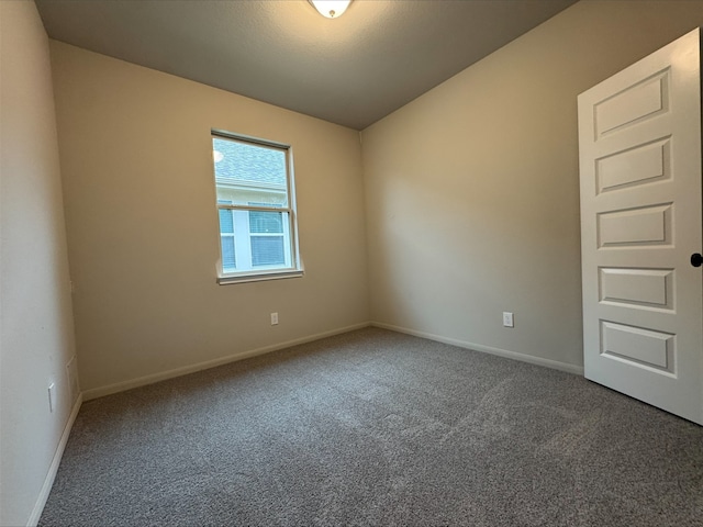 spare room featuring carpet flooring and baseboards