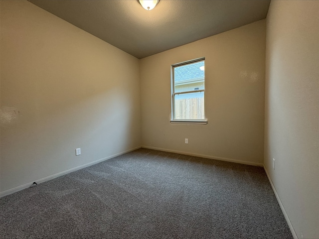 carpeted empty room with baseboards