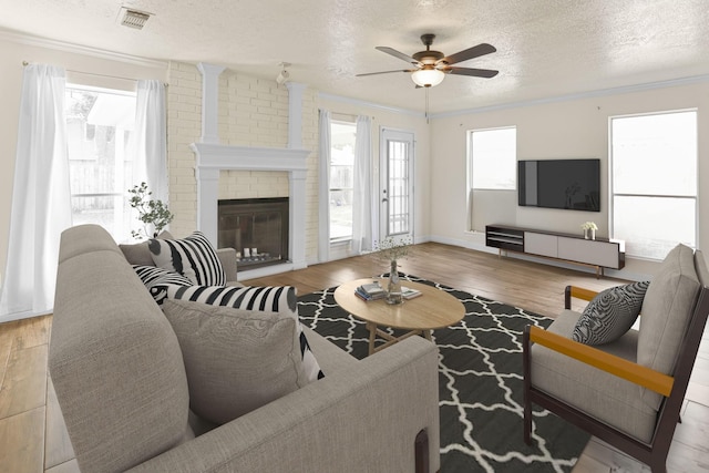 living room with crown molding, light wood-type flooring, and a textured ceiling