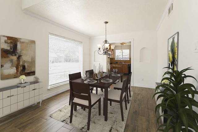 dining room featuring dark hardwood / wood-style flooring, crown molding, sink, and a textured ceiling