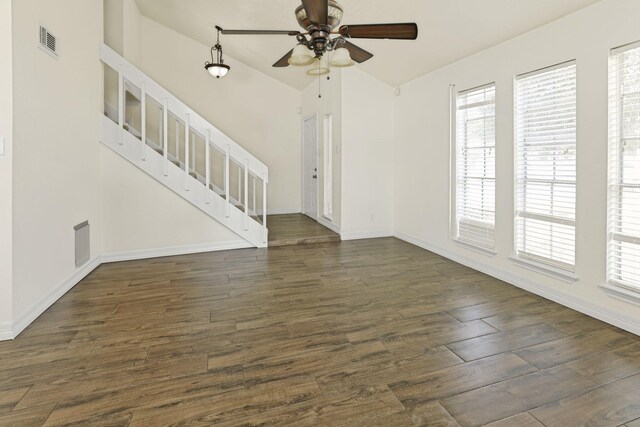 unfurnished living room with ceiling fan, dark hardwood / wood-style floors, and vaulted ceiling