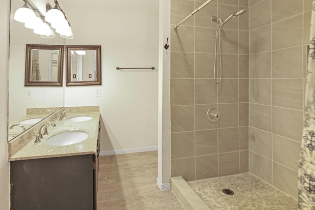 bathroom with a tile shower and vanity