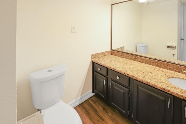 bathroom with hardwood / wood-style floors, vanity, and toilet