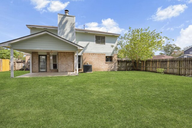 back of property featuring a lawn, central air condition unit, and a patio