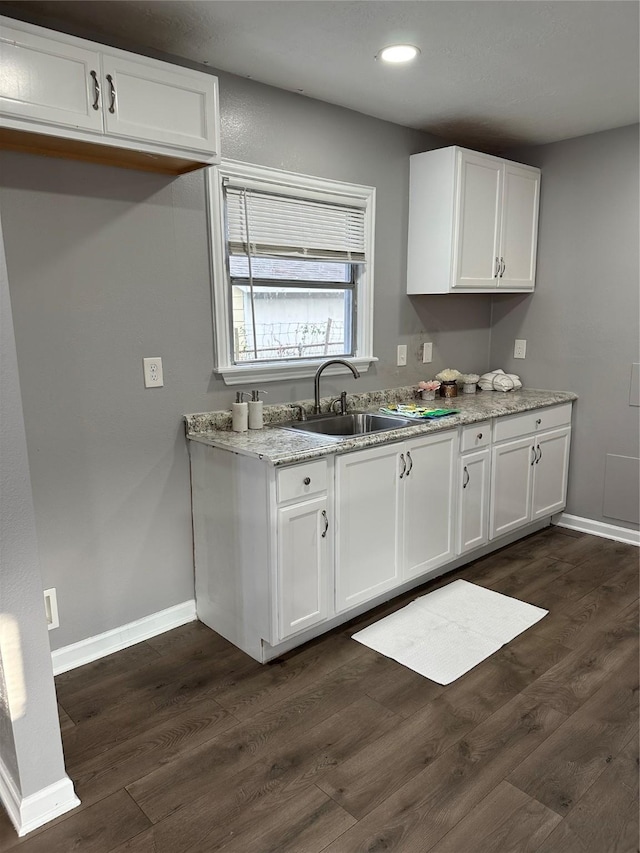 kitchen featuring dark hardwood / wood-style floors, white cabinetry, and sink