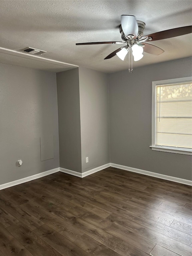 empty room with ceiling fan, dark hardwood / wood-style flooring, and a textured ceiling