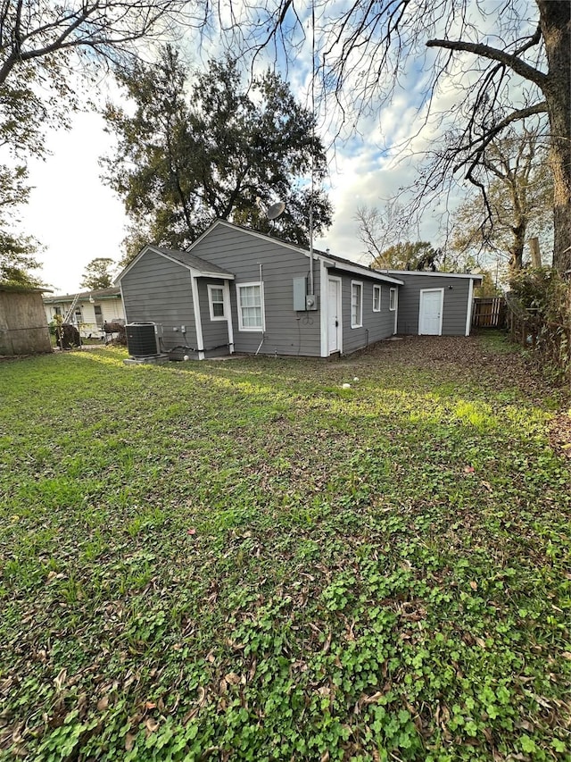 rear view of house featuring a yard and central AC unit