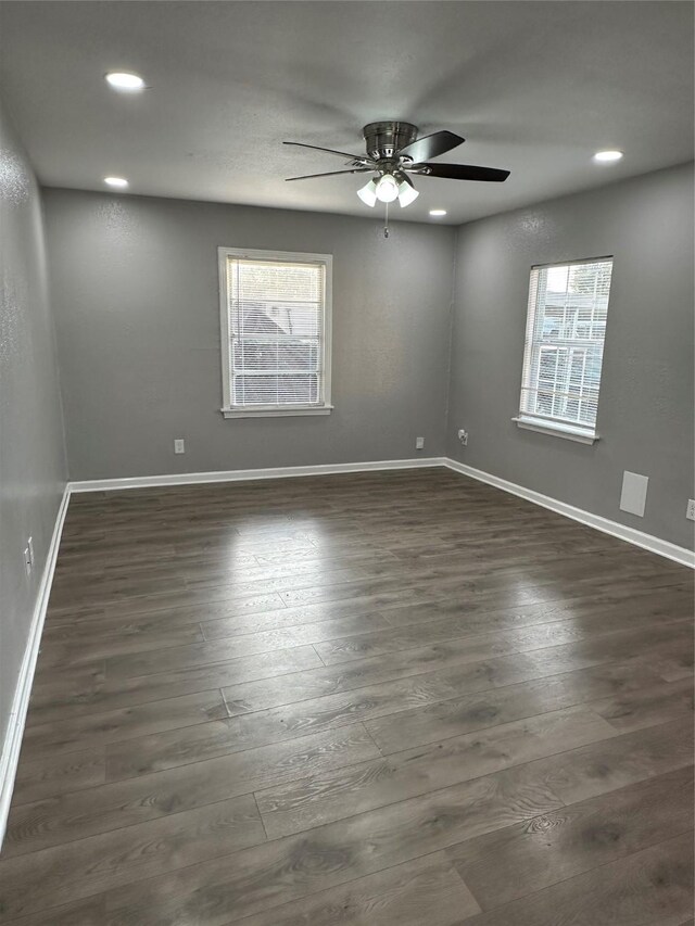 unfurnished room with ceiling fan, plenty of natural light, and dark hardwood / wood-style floors