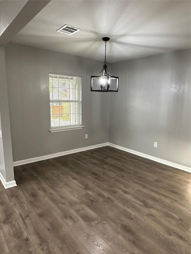 unfurnished dining area featuring dark wood-type flooring and a notable chandelier