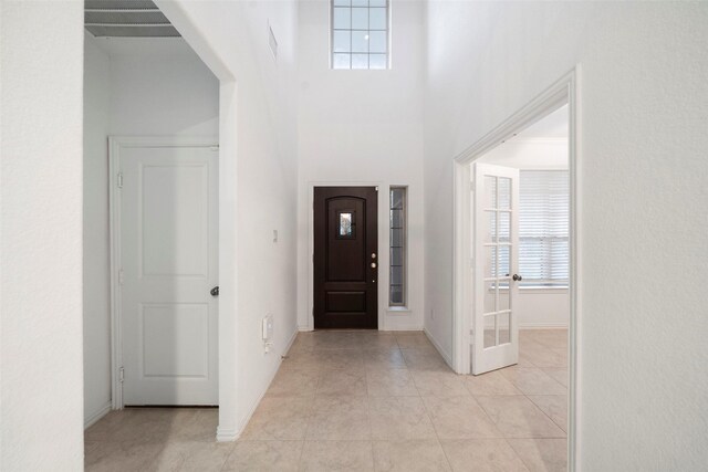 tiled entryway featuring a high ceiling