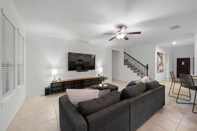 tiled living room featuring ceiling fan and crown molding