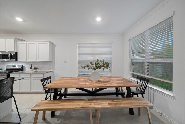 tiled dining room with a healthy amount of sunlight and ornamental molding