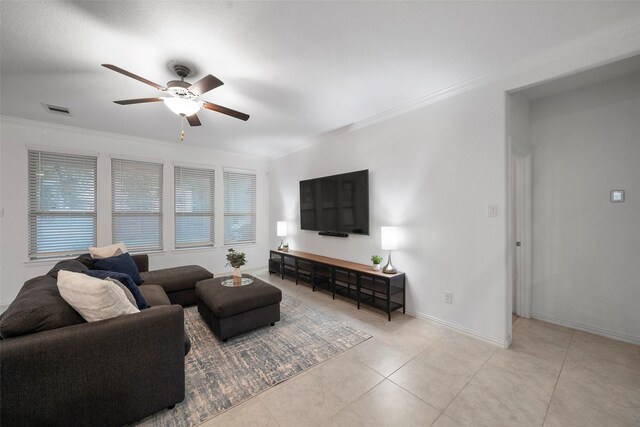 tiled living room with ceiling fan and crown molding