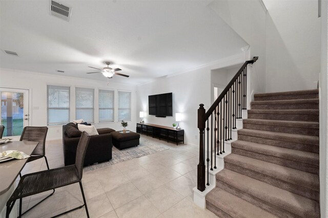 living room with ceiling fan, crown molding, and light tile patterned floors