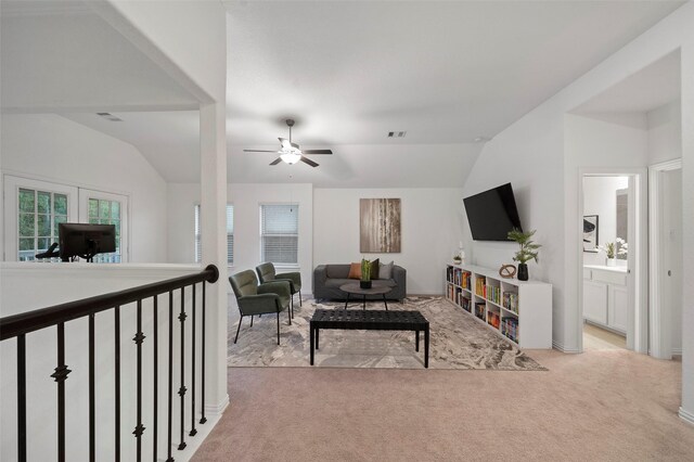 living room with light colored carpet, vaulted ceiling, and ceiling fan