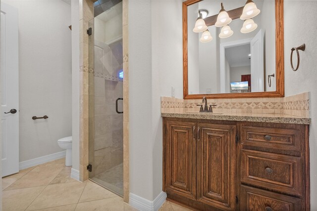 bathroom with tile patterned floors, vanity, an enclosed shower, and toilet