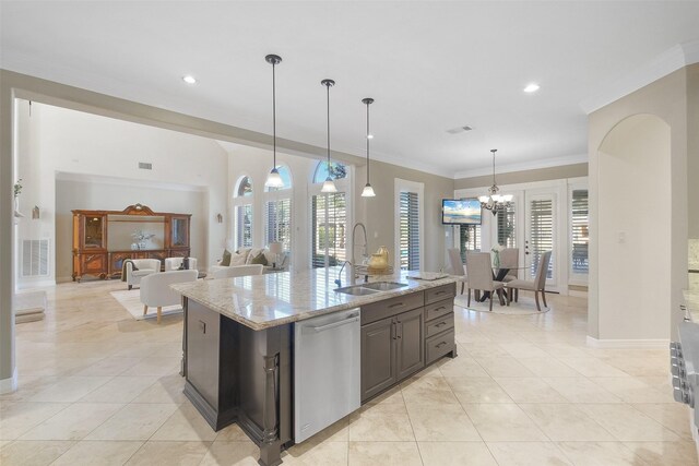 kitchen featuring dishwasher, sink, light stone counters, decorative light fixtures, and a kitchen island with sink