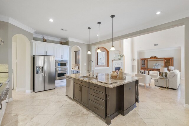 kitchen with dark brown cabinetry, stainless steel appliances, sink, pendant lighting, and white cabinetry