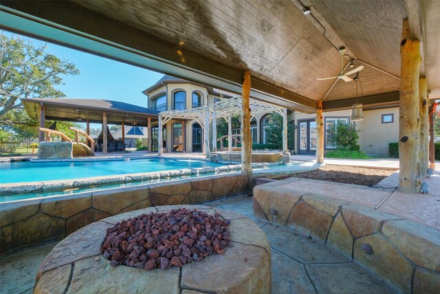 view of swimming pool with a patio area, ceiling fan, and an outdoor fire pit