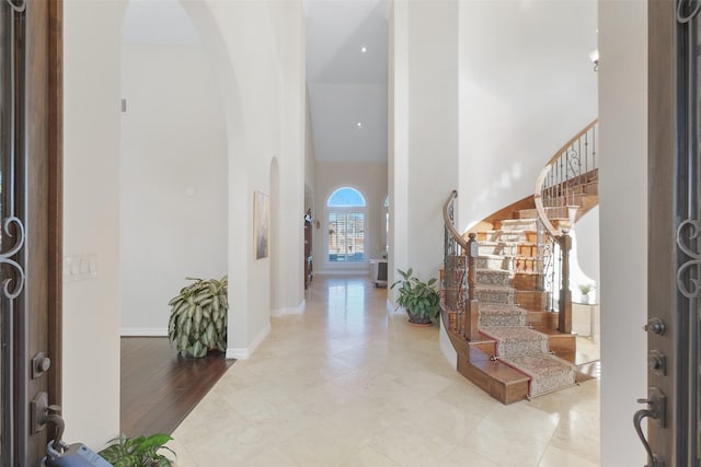 entryway featuring light tile patterned floors and a towering ceiling