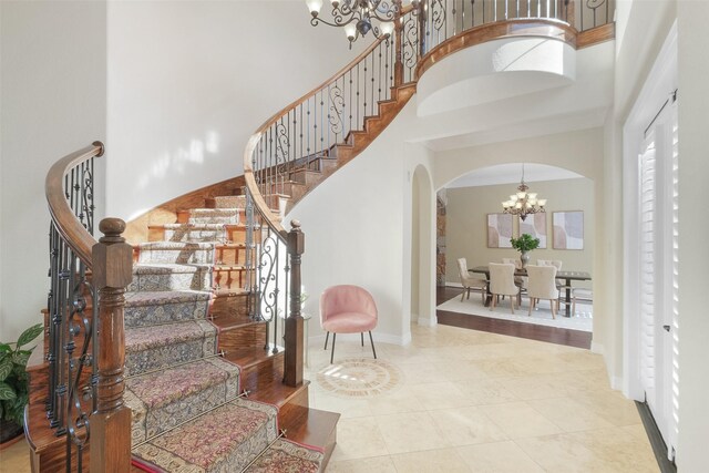 stairs with a high ceiling and an inviting chandelier