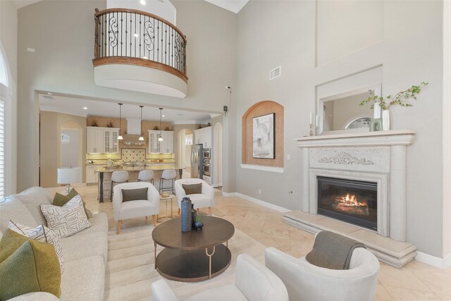 tiled living room featuring a towering ceiling