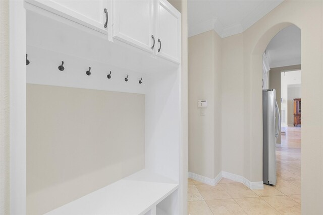 mudroom featuring light tile patterned floors and ornamental molding