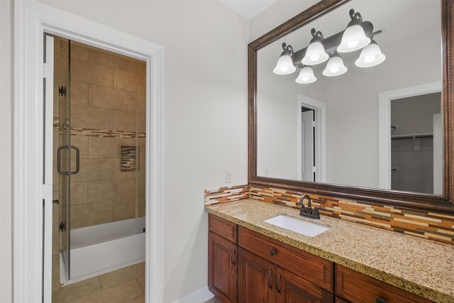 bathroom with tile patterned floors, decorative backsplash, shower / bath combination with glass door, and vanity