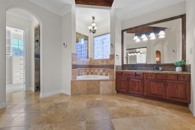 bathroom with a relaxing tiled tub, ornamental molding, vanity, and an inviting chandelier