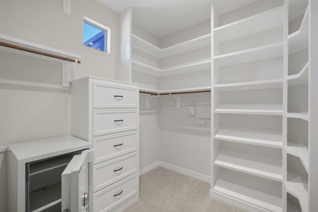 walk in closet featuring light colored carpet