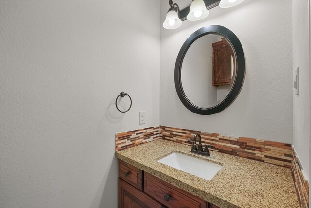 bathroom featuring vanity and tasteful backsplash