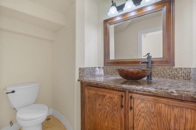 bathroom with vanity, backsplash, toilet, and tile patterned flooring