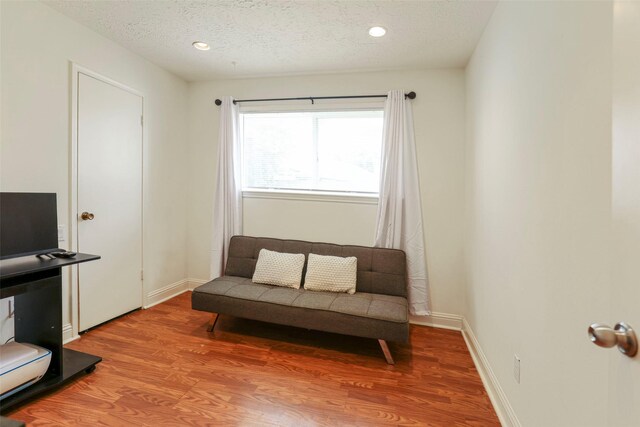 living area with hardwood / wood-style floors and a textured ceiling