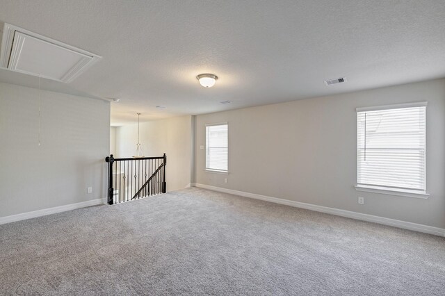 carpeted spare room featuring a textured ceiling