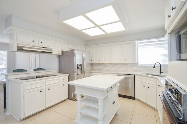 kitchen featuring white cabinetry, sink, light tile patterned floors, a kitchen island, and black appliances