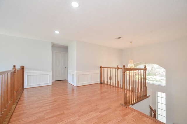 unfurnished room featuring light hardwood / wood-style flooring and a notable chandelier